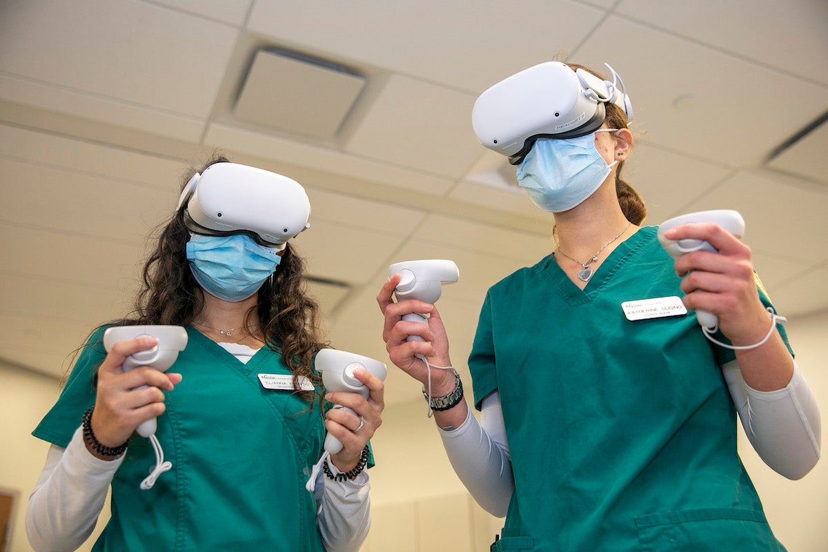 two women wearing nursing uniforms and virtual reality gear