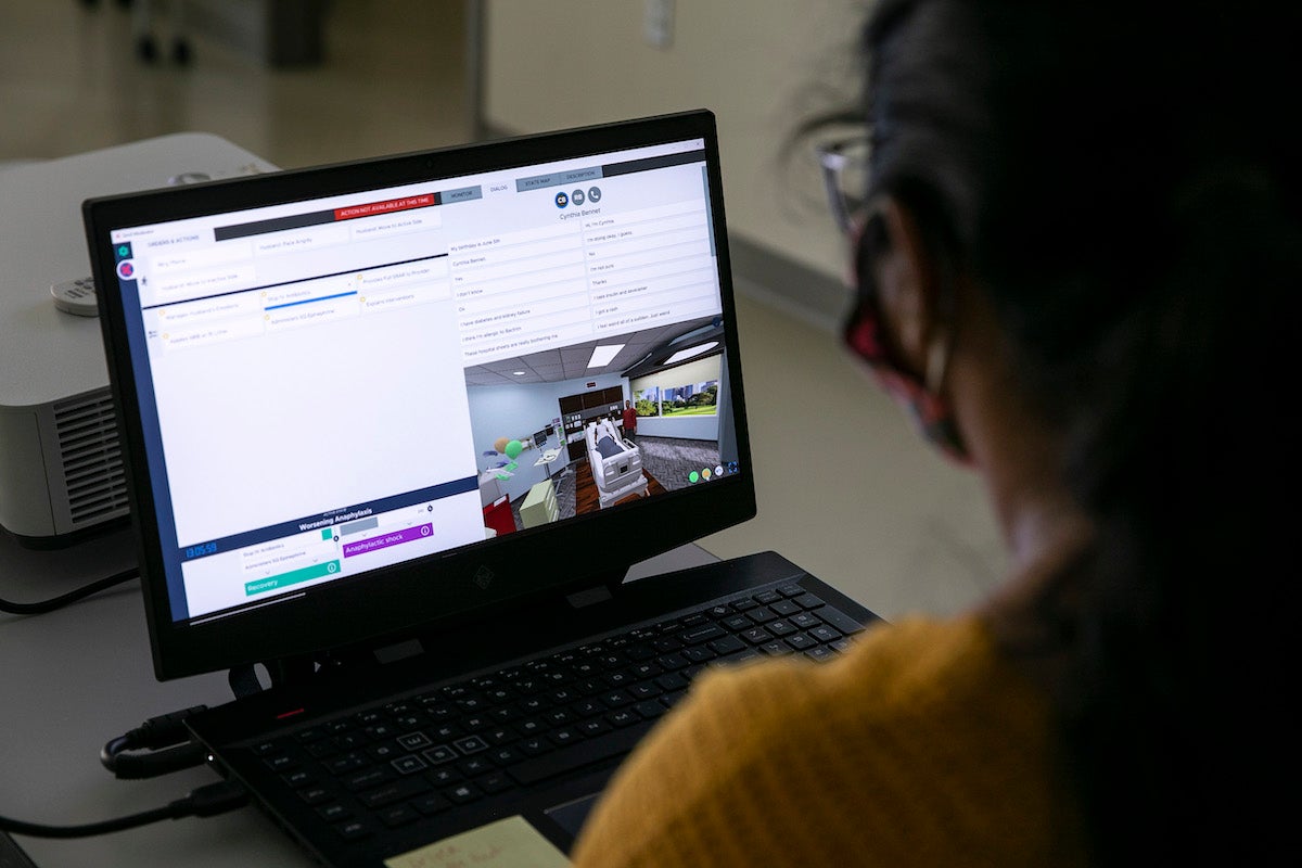 woman watches simulation on laptop