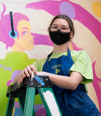 woman on a ladder with mask