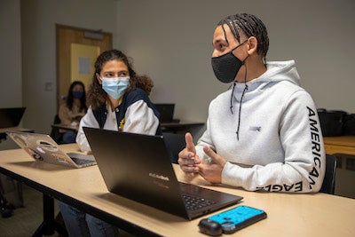 two students with laptop on desk