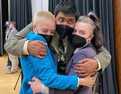 three students hugging