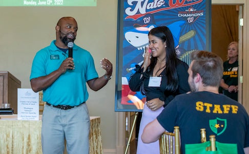 man with microphone introduces young woman