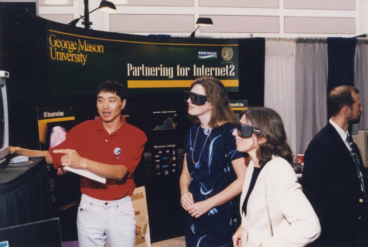 three people looking at an exhibit with special glasses on