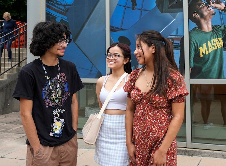 three students on campus one male two females