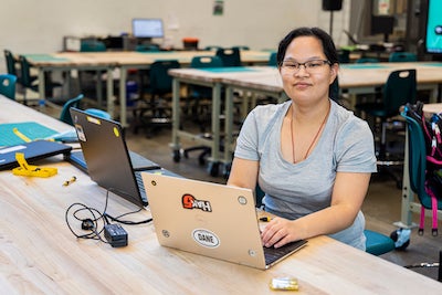 young woman at a work table with laptops