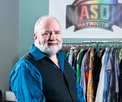 Ric Chollar in front of clothing and a Patriots sign