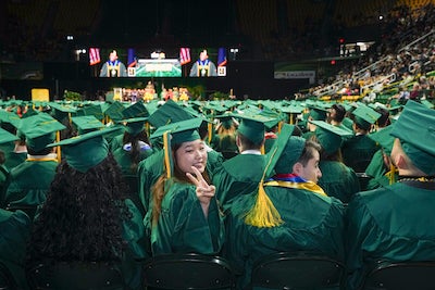 student waving during Commencement
