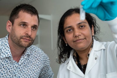 lab photo of a man and a woman looking at a test tube