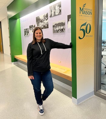 woman stands before an exhibit of photographs