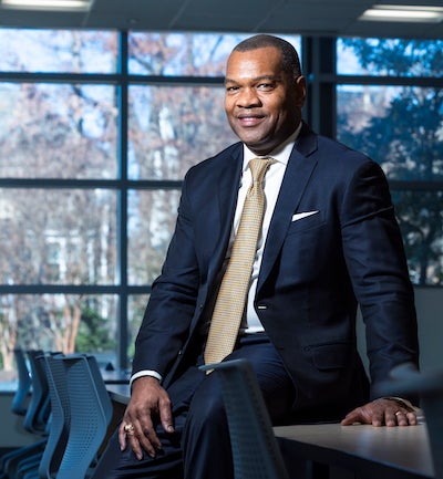 man sitting on a table in front of windows