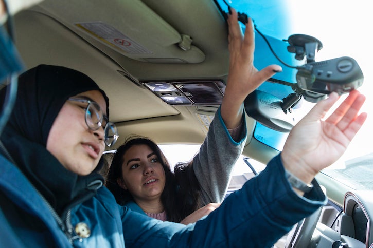 Students installing an air pollution monitor in a car.