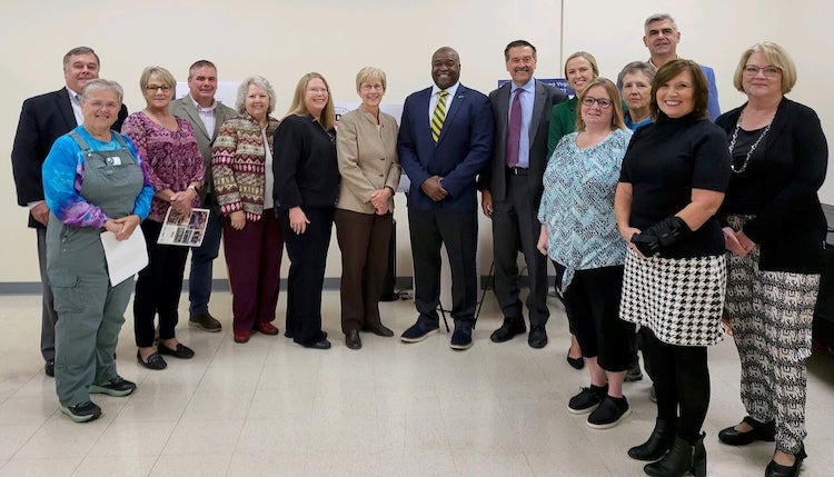 A group of people pose for the camera in a loose semi-circle