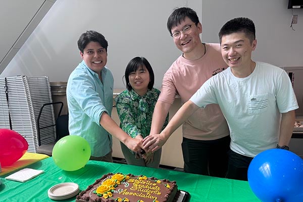 Four students cutting cake