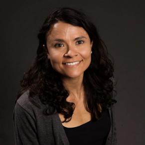 A woman with long, dark hair smiles at the camera.