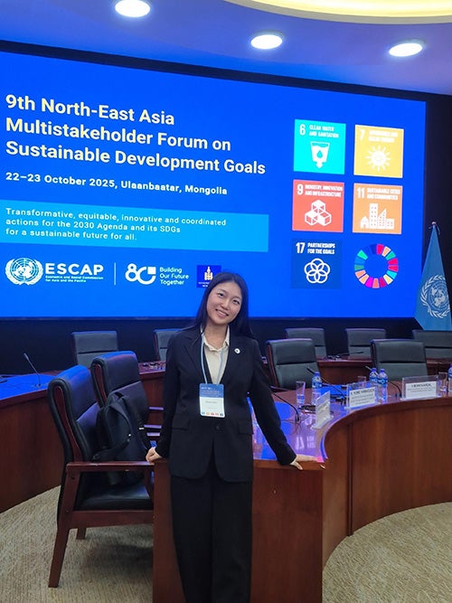 Hyoin Kim standing in the United Nations in professional attire at the 9th North-East Asia Forum on Sustainable Development Goals