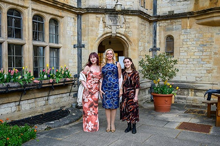 Lisa Misaki Gray, Christina Gizzi, and Karina Korostelina standing outside at Oxford University in formal attire