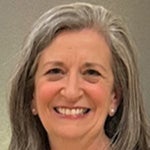 Headshot of Dr. Bonnie Stabile smiling at the camera, with shoulder-length gray hair and a neutral background.