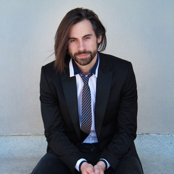 Dr. Jean-Patrick Besingrand in a blue suit with brown hair flowing