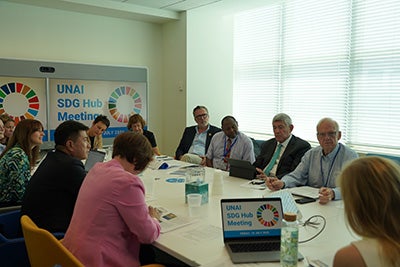 Dean Ozerdem seated at a table with other UNAI Hub chairs