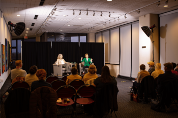 Professor Kennedy and Laura Fredricks speaking in front of audience.