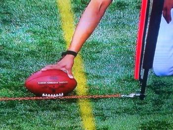A football official measures to determine if a football is past the first-down marker