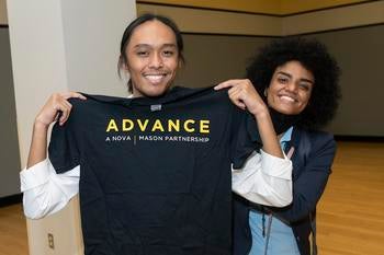George Mason student holds up a black ADVANCE tshirt