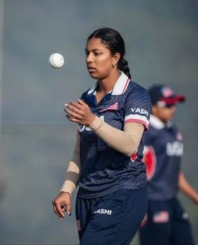 Woman in a USA team jersey standing against a dark backdrop