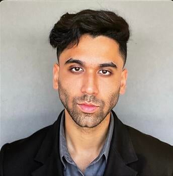 Young man wearing black jacket and gray shirt.