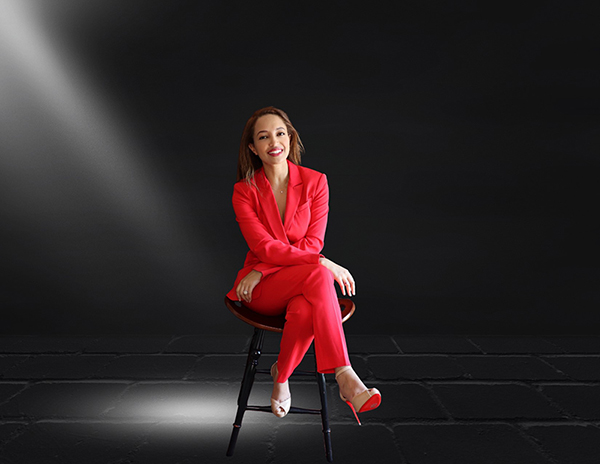 Hiwot Yohannes in a red pantsuit poses in dramatic lighting.