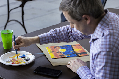 man at a table painting