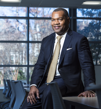 man sitting on a table in front of windows
