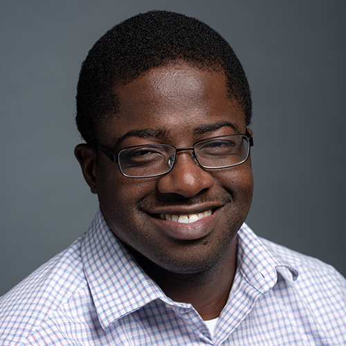 Mason associate professor Tokunbo Fadahunsi wears a blue shirt and glasses in his faculty profile