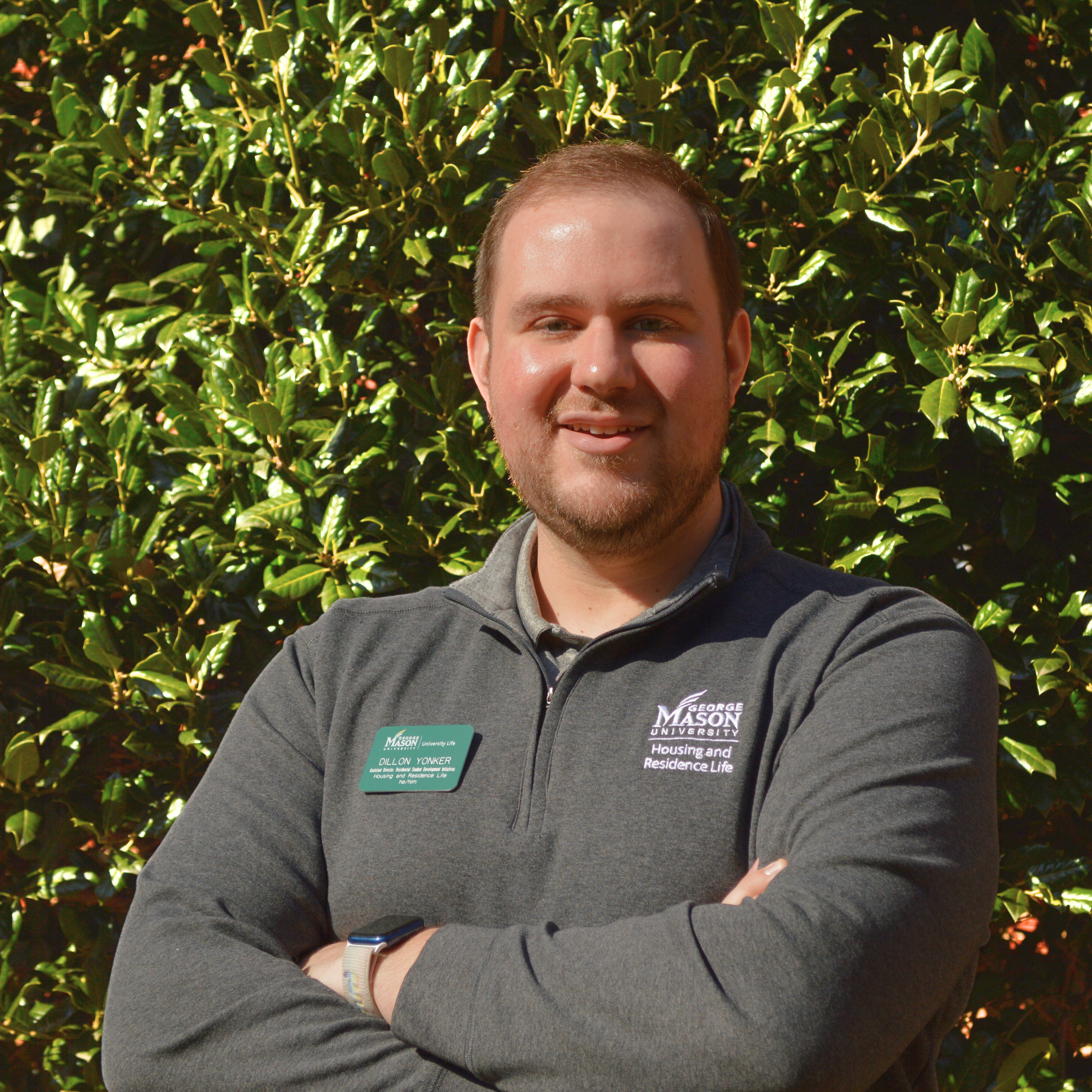 Dillon Yonker in grey long sleeve smiling, arms crossed