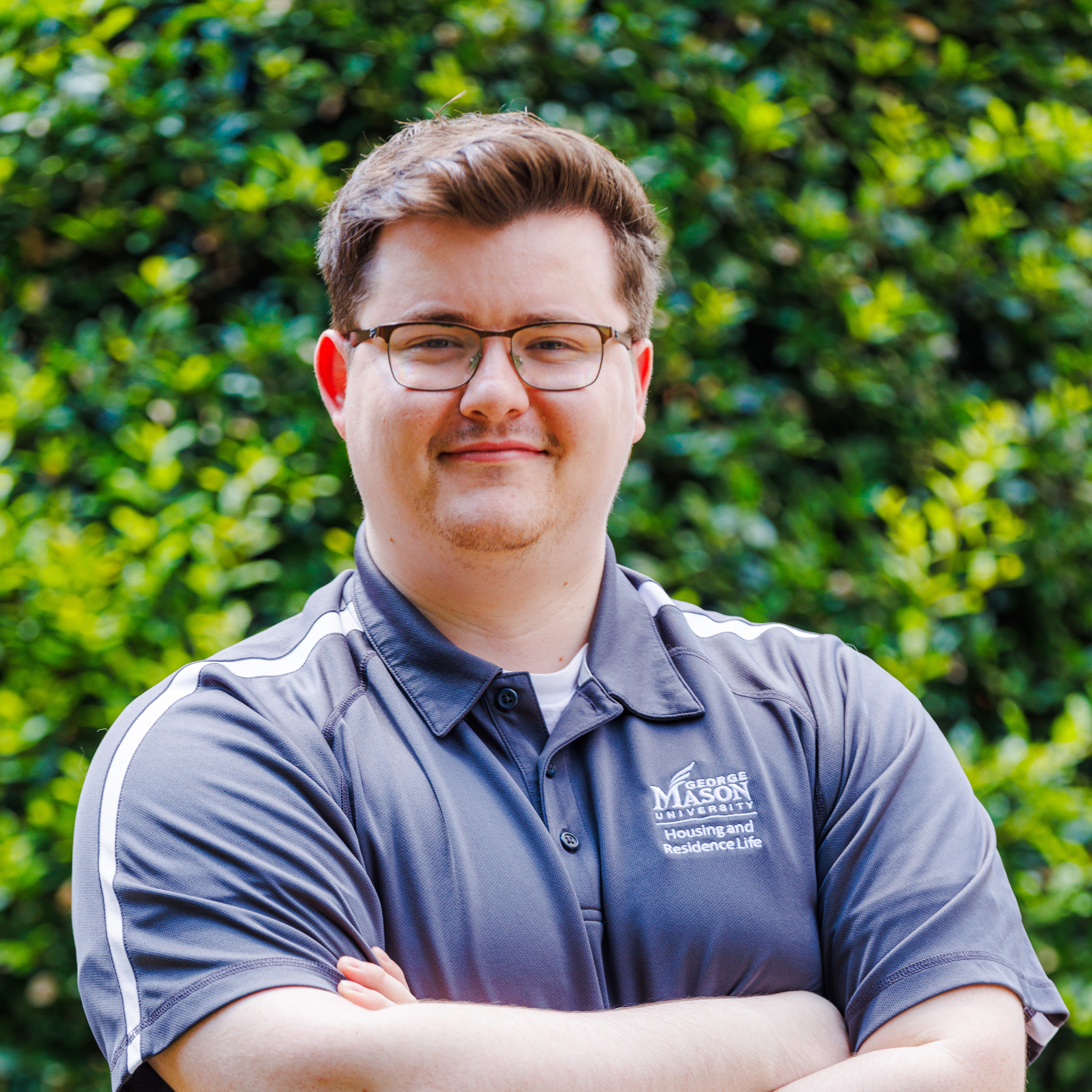 Nick in a grey polo arms crossed smiling