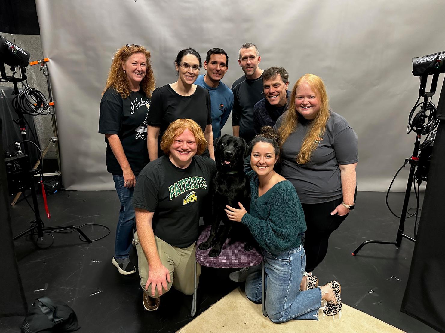 Staff from GMU-TV pose with a dog in the television studio