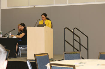 Image of Akshaya Chinnathevar Ramesh speaking at a podium.
