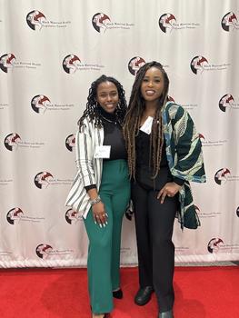 Two women in front of Black Maternal Health banner. On the left, recent George Mason alum Breonna Riddick. On the right, Rochelle Davidson Mhonde.