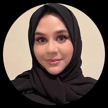 A woman in a dark head scarf and dark eyes gazes at the camera.